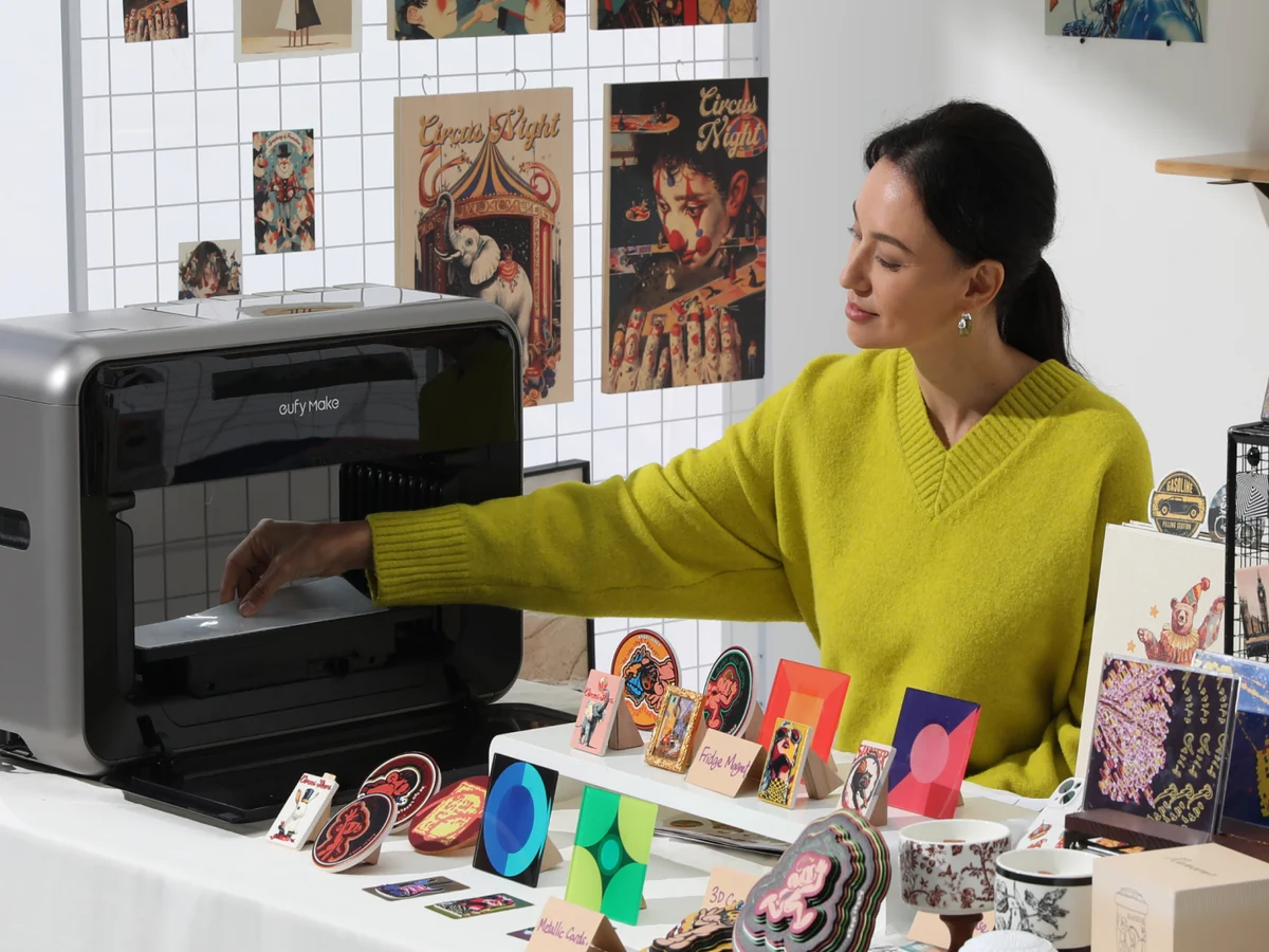 Placing a print in the eufyMake E1 next to a table of finished pieces